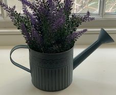 Faux plant in a watering can