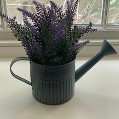 Faux plant in a watering can