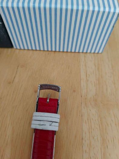 Tommy Hilfiger watch features a distinctive rectangular stainless steel case and a reversible red, white, and blue leather strap