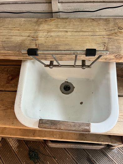 Heavy vintage ceramic basin with a built-in metal rack.
