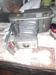 Vintage Large Polaroid Electric Eye Land Camera Model 900, Manufacture between 1960 and 1963. Key Features: Top of the line automatic shutter model featuring a folding bellows design and electric eye light metering