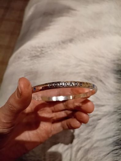 Silver tone bracelet with blue stones and words on it