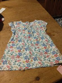 Young Dimension floral print baby dress with a small bow detail at the neckline. New with tags.
