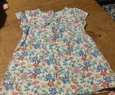 Young Dimension floral print baby dress with a small bow detail at the neckline. New with tags.