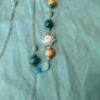 long, colorful beaded necklace featuring a mix of wood, blue, and white floral beads. Image 6