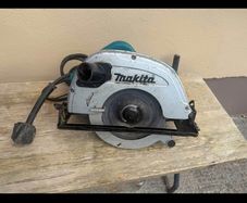 Makita 110V corded circular saw, likely a large 235 mm model, with dust-extraction port