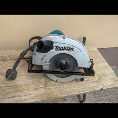 Makita 110V corded circular saw, likely a large 235 mm model, with dust-extraction port