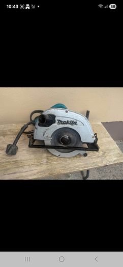 Makita 110V corded circular saw, likely a large 235 mm model, with dust-extraction port