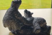 The figurine is a bears sculpture, manufactured by Wolf Originals in Canada.
