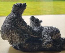 The figurine is a bears sculpture, manufactured by Wolf Originals in Canada.