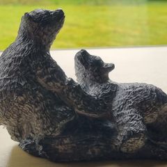 The figurine is a bears sculpture, manufactured by Wolf Originals in Canada.