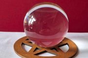 Crystal glass ball on wooden pentagram base.