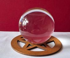 Crystal glass ball on wooden pentagram base.