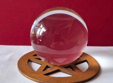 Crystal glass ball on wooden pentagram base.