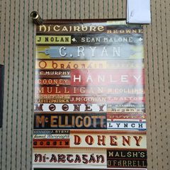 Large poster of Irish name signs on shops and pubs