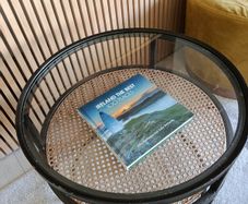 Round glass and rattan side table