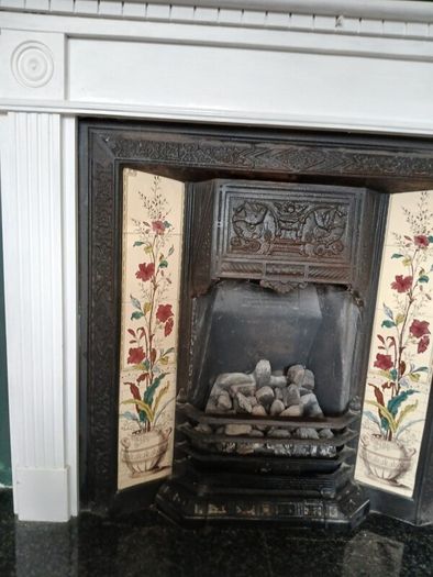 Fireplace in cast iron with wooden surround (painted white) and black marble hearth.   Perfect condition