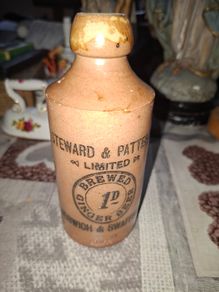 Antique stoneware ginger beer bottle from the Norfolk brewer Steward & Patteson Limited, featuring a "1D" (one penny) price mark