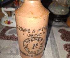 Antique stoneware ginger beer bottle from the Norfolk brewer Steward & Patteson Limited, featuring a "1D" (one penny) price mark
