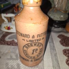 Antique stoneware ginger beer bottle from the Norfolk brewer Steward & Patteson Limited, featuring a "1D" (one penny) price mark