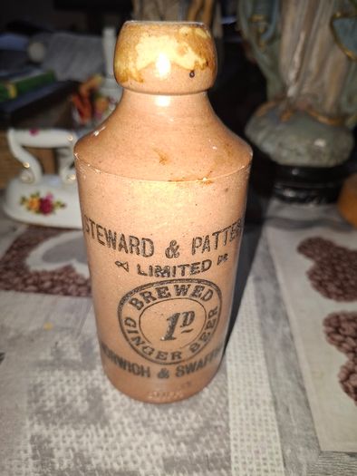 Antique stoneware ginger beer bottle from the Norfolk brewer Steward & Patteson Limited, featuring a "1D" (one penny) price mark