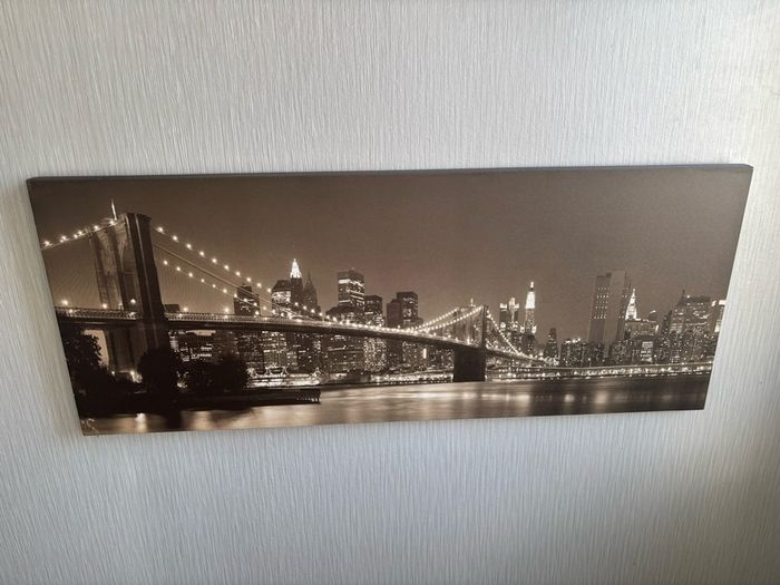 This sepia-toned panoramic canvas print features a classic night view of the Brooklyn Bridge and the New York City skyline