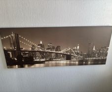 This sepia-toned panoramic canvas print features a classic night view of the Brooklyn Bridge and the New York City skyline