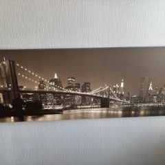 This sepia-toned panoramic canvas print features a classic night view of the Brooklyn Bridge and the New York City skyline