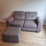 Grey two-seater sofa bed with matching storage footstool Image 6
