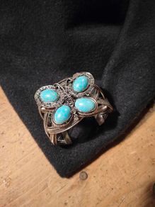 silver tone butterfly cuff bracelet featuring faux turquoise stones and intricate wire work.