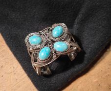 silver tone butterfly cuff bracelet featuring faux turquoise stones and intricate wire work.