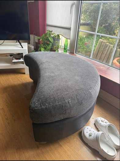 Grey crescent-shaped footstool with detachable top