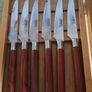 A Newbridge Cuisine set of six steak knives with serrated blades and wooden handles. Image 3