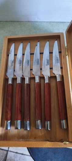 A Newbridge Cuisine set of six steak knives with serrated blades and wooden handles.