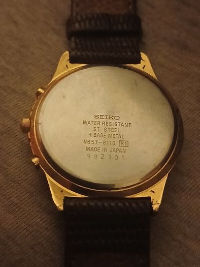 This is a gold-tone Seiko Vintage V657-8110 quartz chronograph watch featuring a cream dial with Roman numerals and three sub-dials
