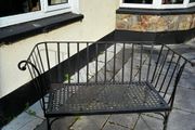 Curved wrought iron garden bench