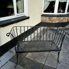 Curved wrought iron garden bench