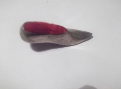 a vintage solid silver pin cushion in the shape of a shoe
