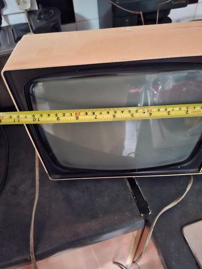 Ideal Prop, Vintage Working Boots Audio TV12 Portable Black and White CRT Television, featuring a cream plastic casing with side control dials and a 12 inch screen. Designed with dual power capabilities supporting standard mains voltage (240V) as well as 