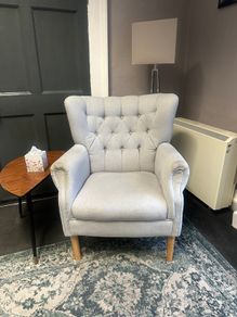 Grey button-back armchair