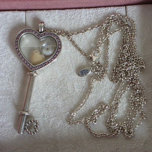Pandora sterling silver key necklace with a heart,shaped floating locket and pink sparkling stones. Includes the two petite charms