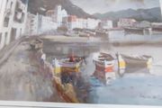 Framed signed print of sea side village.