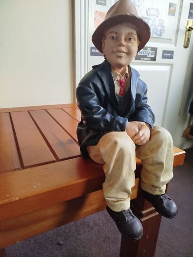 Resin sculpture of a seated boy