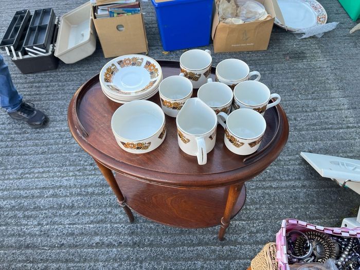 The set shown is a 1970s Arklow Pottery "Studio Kraft" tea/coffee set manufactured in County Wicklow, Ireland. It features a classic 1970s mid-century retro floral pattern in amber, orange, and brown tones with gold trim