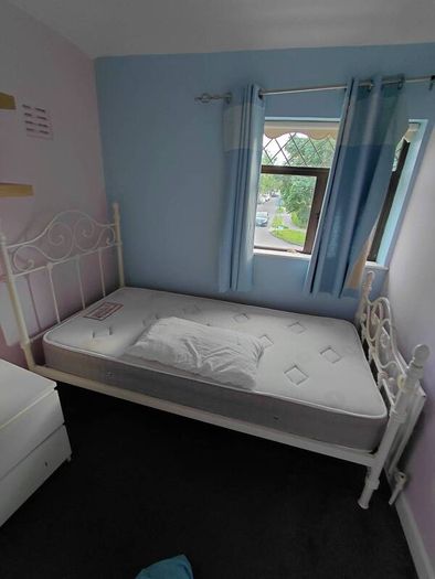 white metal single bed with mattress.