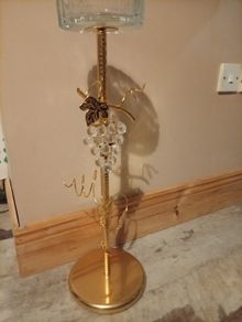 gold-finished, freestanding decorative stand features a clear glass top tray