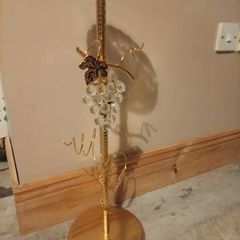gold-finished, freestanding decorative stand features a clear glass top tray