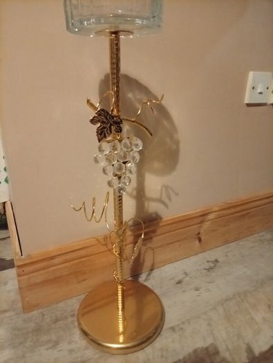 gold-finished, freestanding decorative stand features a clear glass top tray