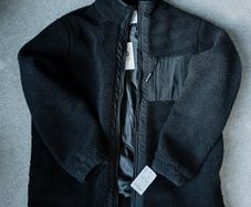 A black fleece jacket with a zipper lining and raincoat inserts. New with tags. Brand: Nordom. Size: XL.
