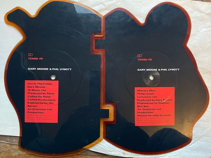 Rare and collectible Gary Moore and Phil Lynott special 2 in 1 shaped picture disc. Out in the fields and military man. Bought this new back in the day. Records were never played but picture disc discoloured over time as all versions did. Still highly col